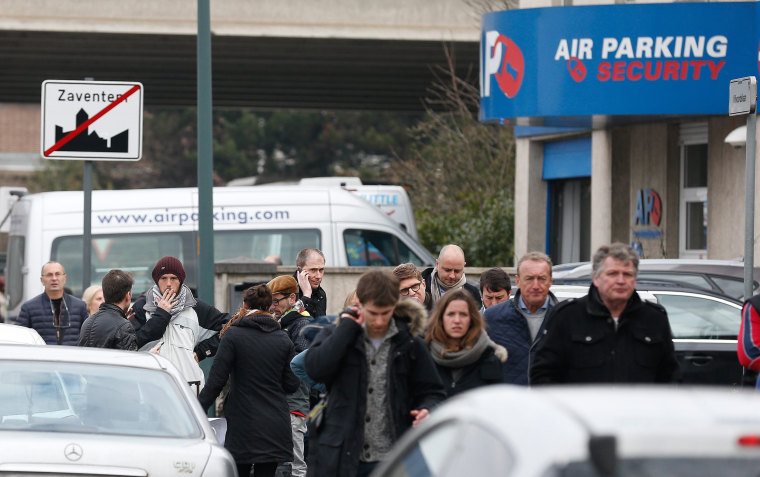 Image: People leave the airport area after the explosions