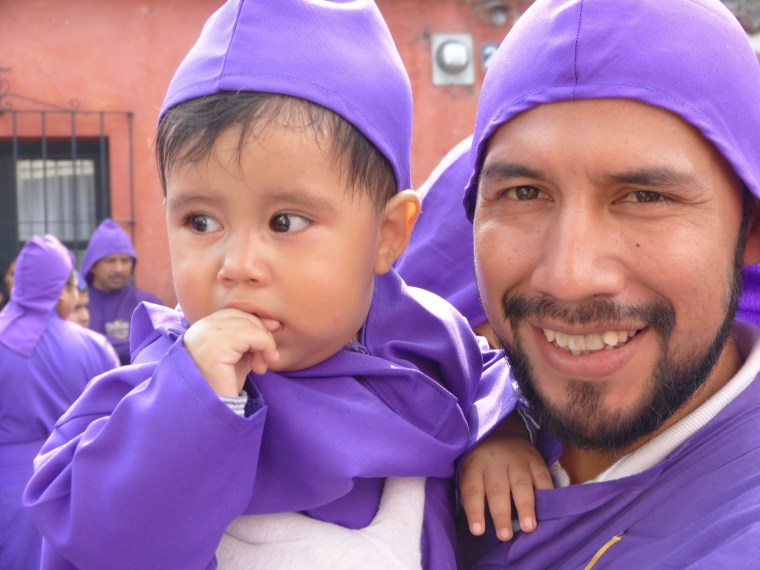 Father and son dressed as the shrouded carriers known as cucuruchos.