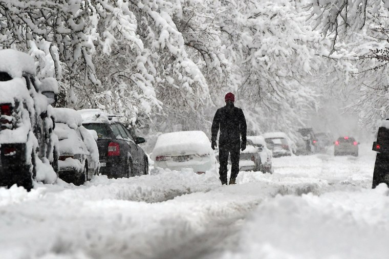 Image: A man walks down a street in Boulder, Colo.