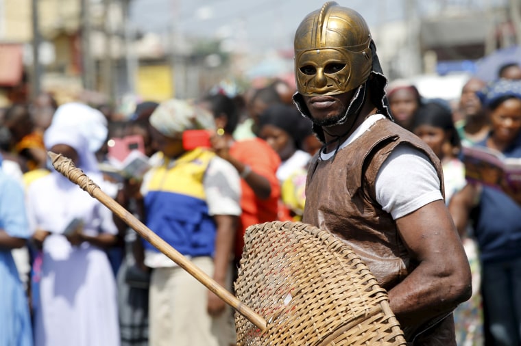 Image: A man dressed up as a soldier takes part in a re-enactment of the crucifixion of Jesus Christ on Good Friday along a road near St. Leo's Catholic church in Lagos