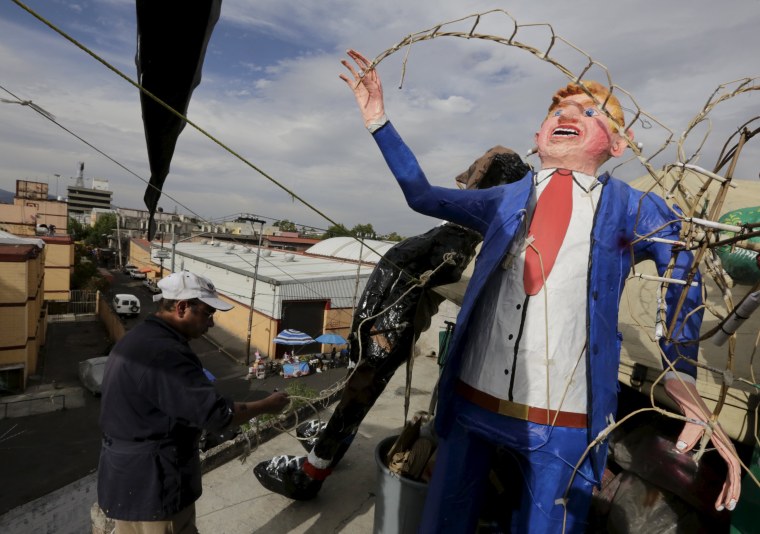 Image: A craftsman works beside an effigy of U.S. Republican presidential hopeful Donald Trump at his workshop before it was burned during an Easter ritual late on Saturday in Mexico City