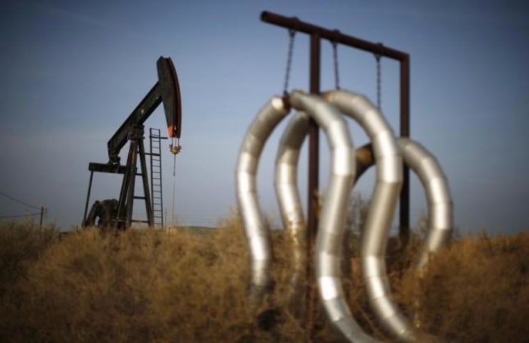 Pump jack and pipes are seen on an oil field near Bakersfield on a foggy day, California