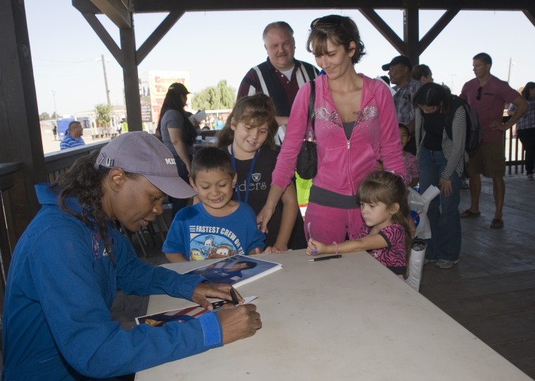 NASA Astronaut Yvonne Cagle posed for photos and signed autographs for many excited
children at the Reachout for the Rainbow After School Science Festival on Feb. 27, 2011.