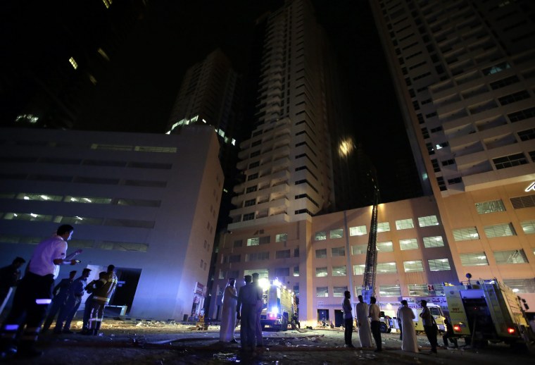 Image: Members of the Civil Defense and fire services extinguish a fire at residential buildings