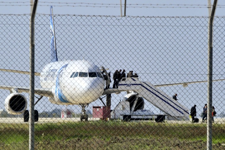 Image: Passengers evacuate a hijacked EgyptAir Airbus 320 plane at Larnaca airport
