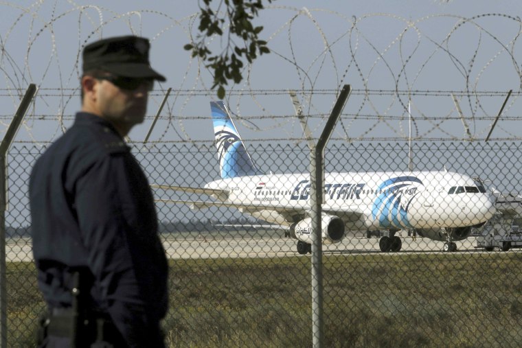 Image: A policeman stands guard at the airport near a hijacked plane