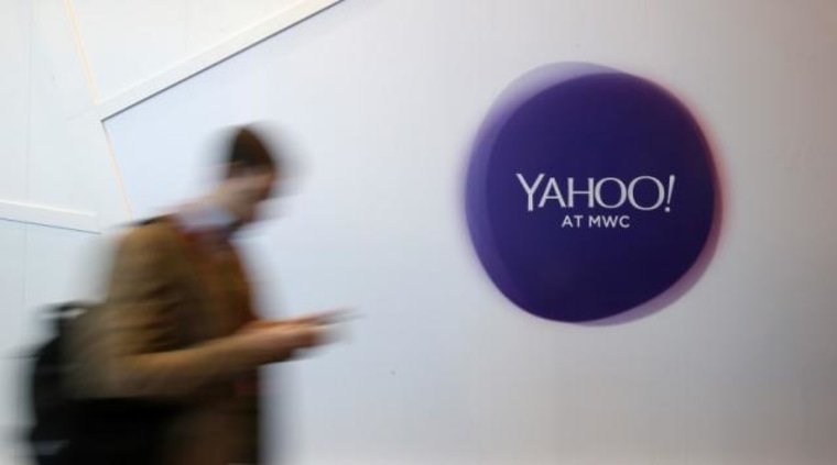 A man walks past a Yahoo logo during the Mobile World Congress in Barcelona