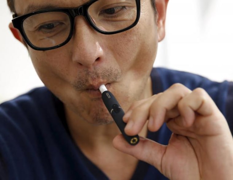 A customer tries a Philip Morris' "iQOS" smokeless tobacco at an iQOS store in Tokyo
