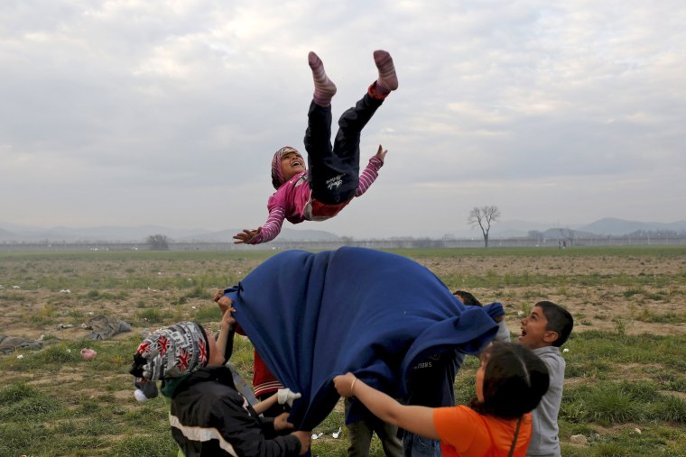 Image: Children play at a makeshift camp for migrants and refugees at the Greek-Macedonian border near the village of Idomeni