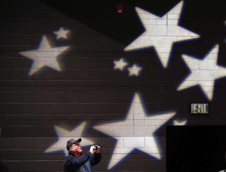 Image: An attendee takes a photograph at a campaign event for U.S. Republican presidential candidate Donald Trump in De Pere