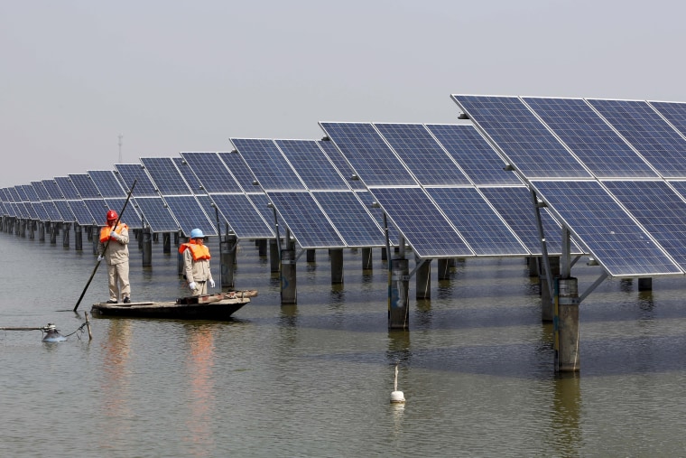 Image: Energy workers examine solar panels in China