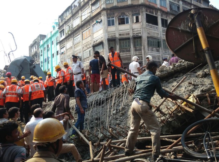 Image: Locals and rescue workers clear the rubble of the partially collapsed overpass