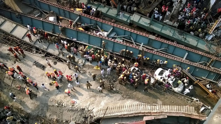 Image: People try to assist at a vehicle that is stuck in the rubble of the collapsed bridge