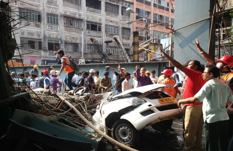 Image: Locals and rescue workers clear the rubble of a partially collapsed overpass