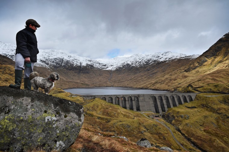 Image: A boy and his dog view Cruachan hydro electric power station in Dalmally, Scotland