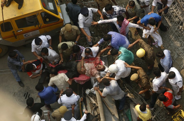 Image: Rescue members carry a victim from the site of an under-construction flyover that collapsed in Kolkata