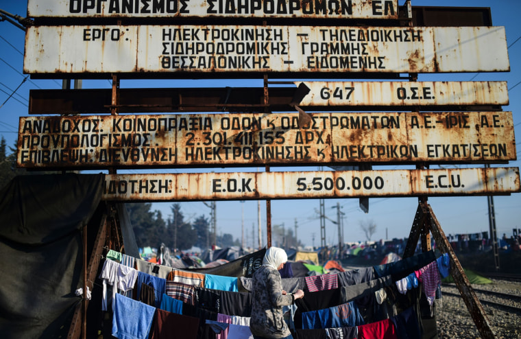 Image: A refugee hangs clothes in the makeshift camp at the Greek-Macedonian border