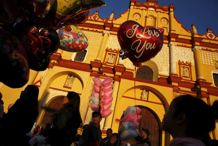 A girl looks at balloons in front of the Cathedral during Valentine's Day in San Cristobal de Las Casas.