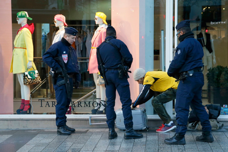 Image: French police stop a man and conduct a search on the Champs Elysees before the start of the 40th Paris Marathon