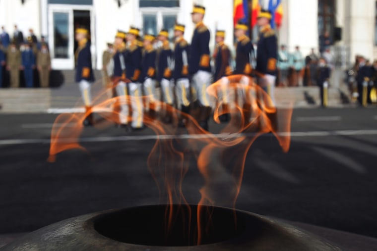 Image: Romanian soldiers are seen through the flame