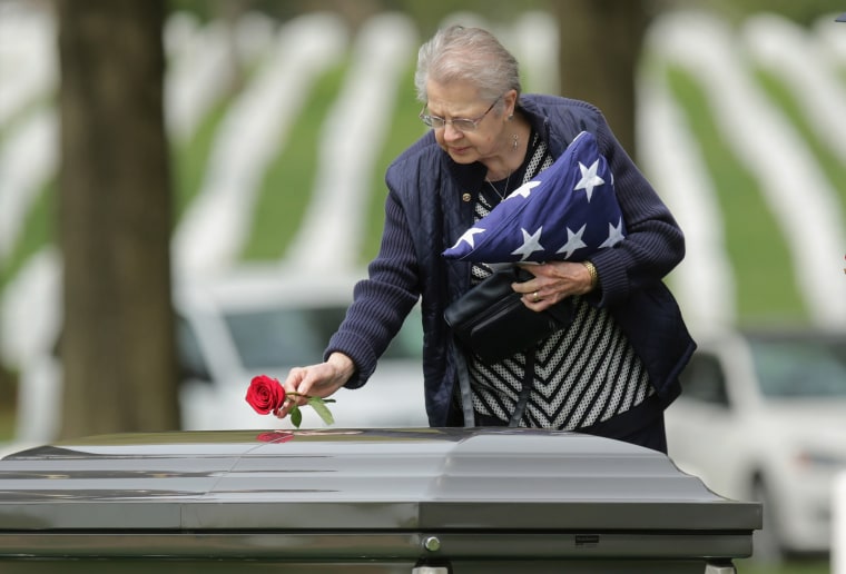 Image: Urbana Warfel, 81, places a rose on the casket of her brother, Korean War solider