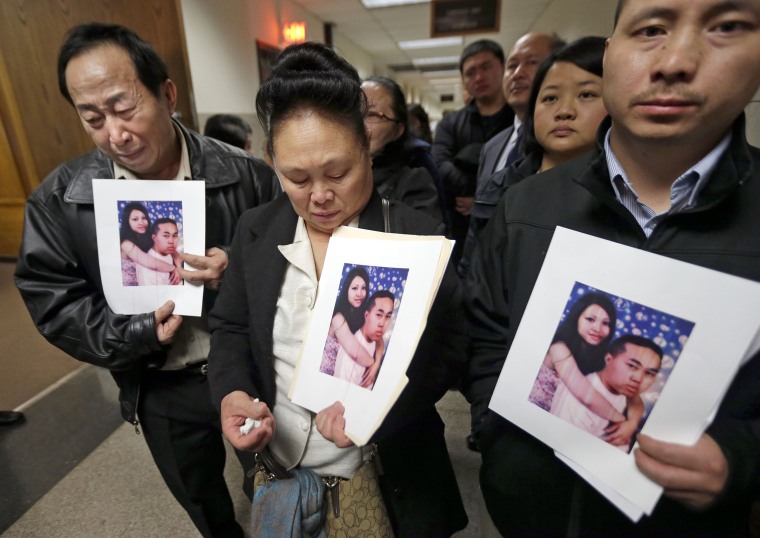 From left, the parents and brother of Mai Vue hold photos of Mai and Phia Vue after Dan Popp appeared in a Milwaukee County Court on April 6. 
