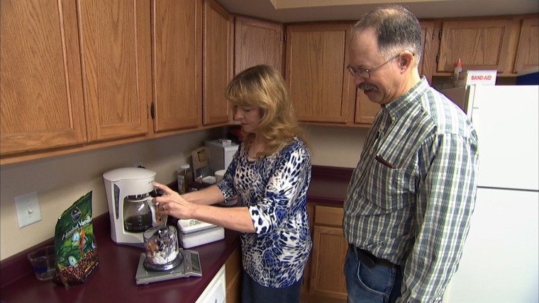 Jennifer Stewart, 54, with husband meal prepping in kitchen.