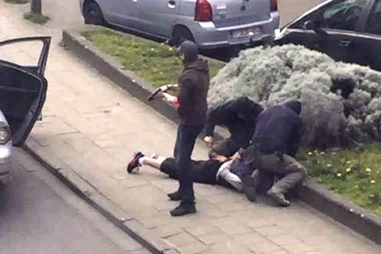 Image: Police officers detain a suspect during a raid in which fugitive Mohamed Abrini was arrested in Anderlecht in this still image taken from video