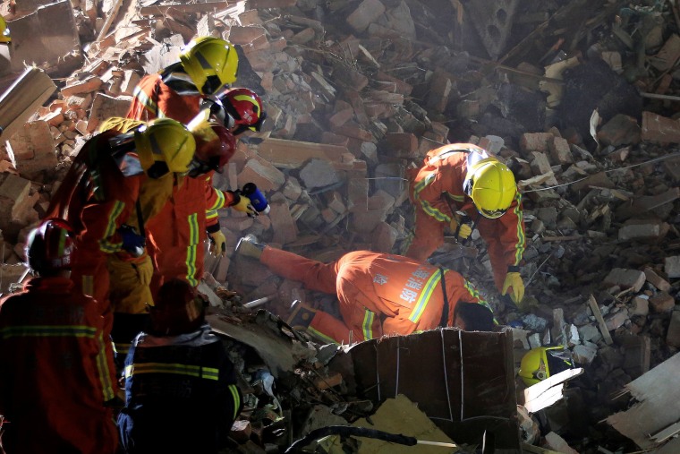 Image: Rescue workers search at the site after a three-storey residential building collapsed in Shanghai