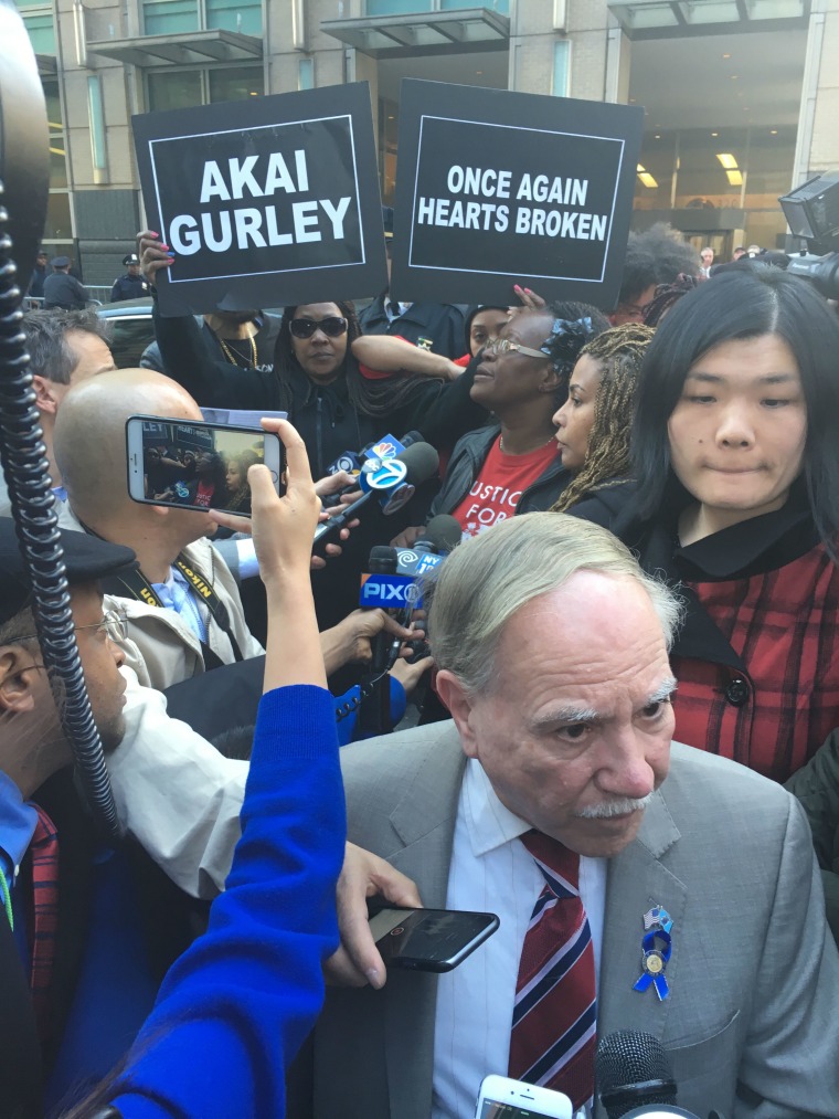 New York State Assemblyman William Colton (D-Brooklyn), a Peter Liang supporter, speaks to reporters about Justice Danny Chun's decision to deny Liang a new trial. Family and friends of Akai Gurley, whom Liang fatally shot in 2014, protest in the background.
