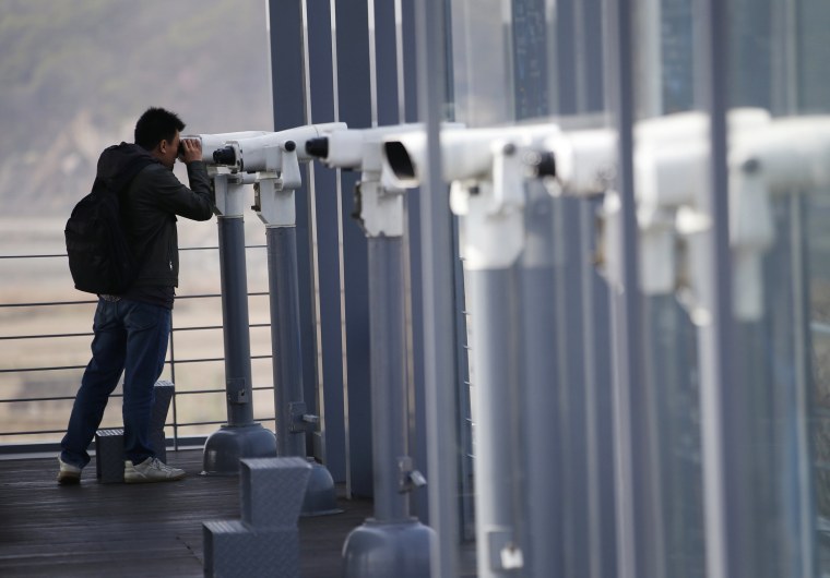Image: A man uses binoculars to watch the North side at the Imjingak Pavilion