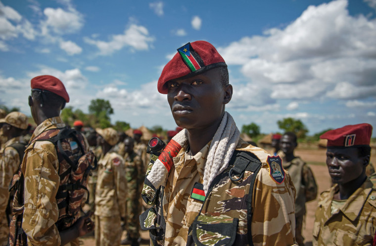 Image: The Sudan People's Liberation Army soldiers stand at attention at a containment site outside Juba