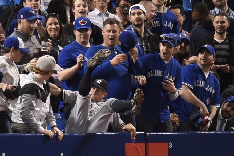 Image: New York Yankees' Brett Gardner falls into the stands after catching a foul ball