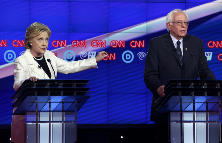 Image: Democratic U.S. presidential candidate Clinton gestures towards rival candidate Sanders as she speaks during a Democratic debate in New York