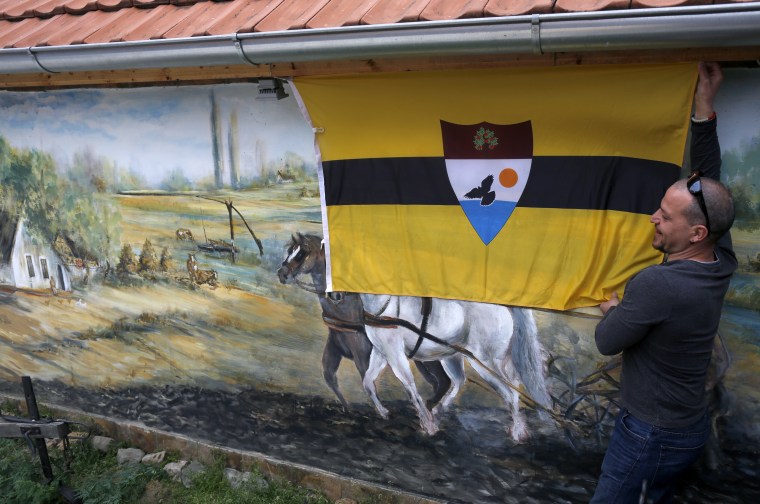 A man fixing the Liberland flag onto a wall in a private compound in Backi Monostor, Serbia, on  May 1, 2015.