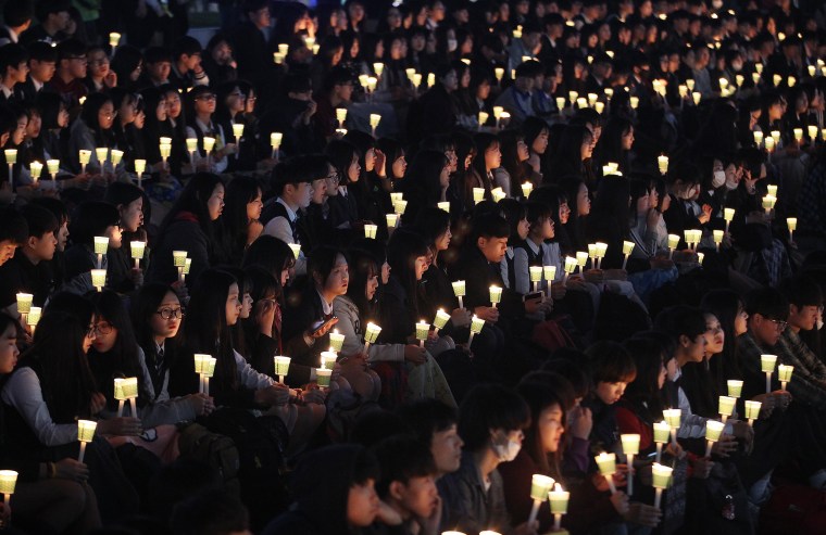 Image: High school students hold candles to pay their respects to the victims of the sunken ferry Sewol