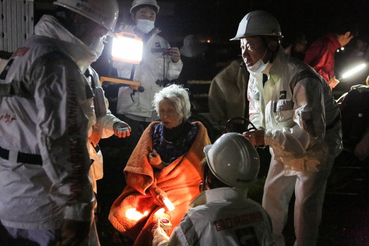 Image: Rescue workers take care of an elderly woman