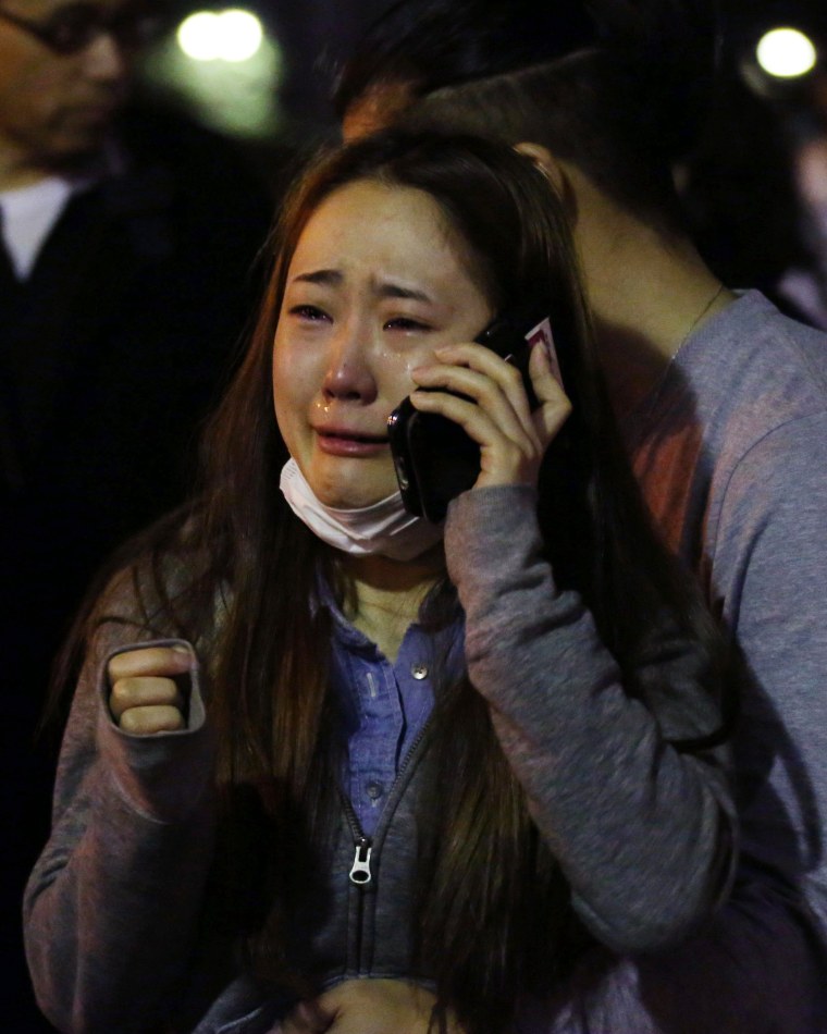 Image: An evacuee cries as she talks on a mobile phone at a park in Kumamoto
