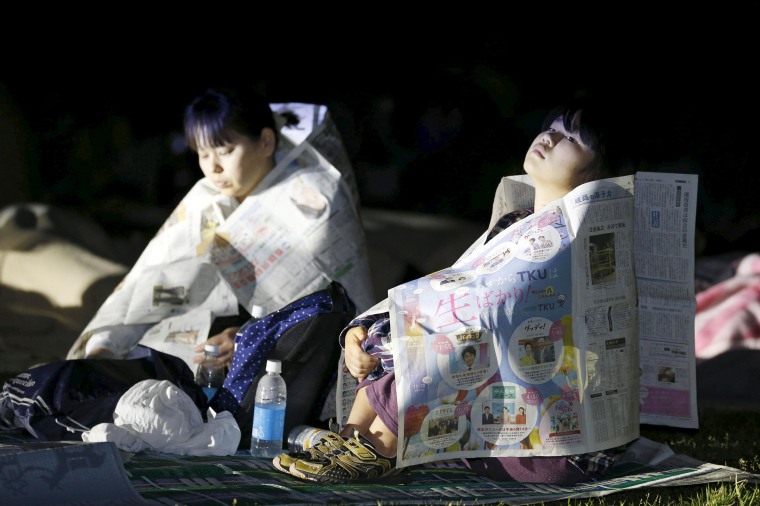 Image: Evacuees use newspapers to warm themselves at Prefectural University of Kumamoto after an earthquake in Kumamoto, southern Japan