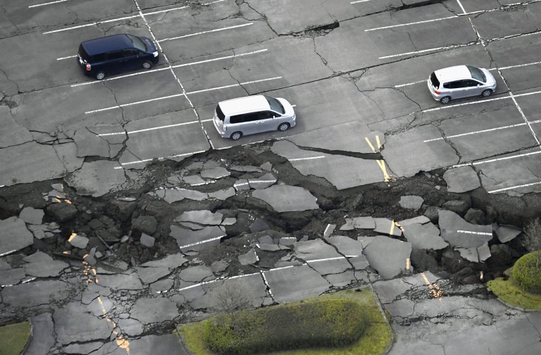 Image: Vehicles sit in a parking lot damaged by an earthquake