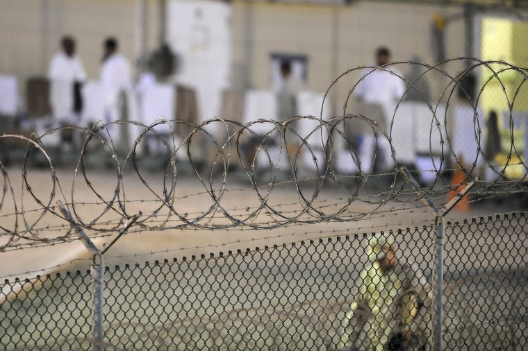 Image: File photo of a Navy guard patrolling Camp Delta’s detainee recreation yard during the early morning at Guantanamo Bay naval base