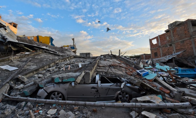 Image: A car is crashed beneath rubble in Manta, Ecuador