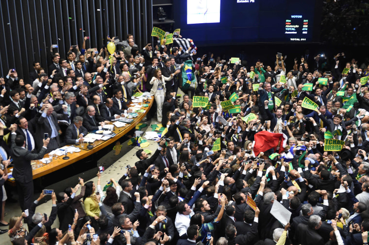 Image: Lawmakers celebrate the decision to proceed with impeachment proceedings against the president at the Congress in Brasilia