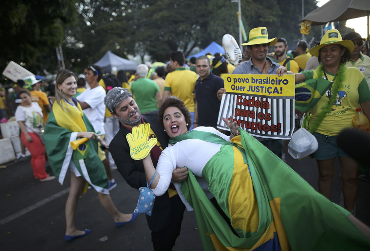 Image:Pro-impeachment supporters demonstrate as they carry a sign reading, \"The people want justice. Prison for the corrupt.\"