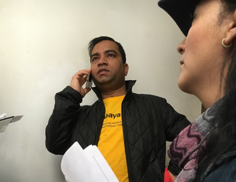 Rasel Rahman makes a phone call to see if a registered voter still lives in an apartment building.