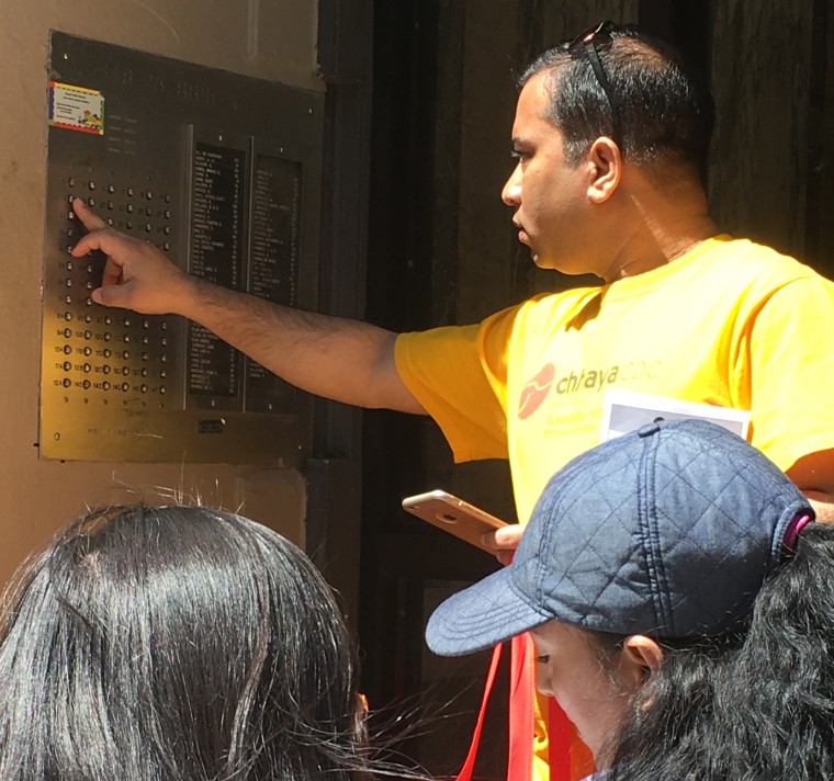 Rasel Rahman looks for the buzzer of a registered voter as Paola Di Lorenzo and Yangchen Chadotsang check their voter list.
