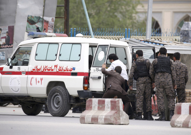 Image: Afghan security forces transfer injured security personnel into an ambulance after a suicide car bomb attack in Kabul