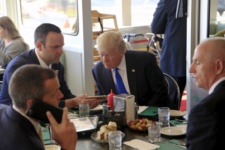 Image: U.S. Republican presidential candidate Donald Trump talks with his campaign staff as he stops in for breakfast at Miss Katie's Diner, while campaigning in Wisconsin