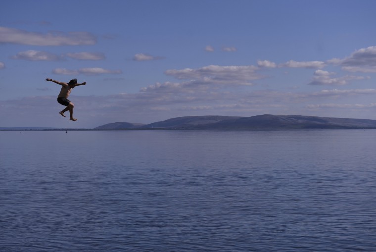 Image: A young man dives into the water at Salthill beach in Galway