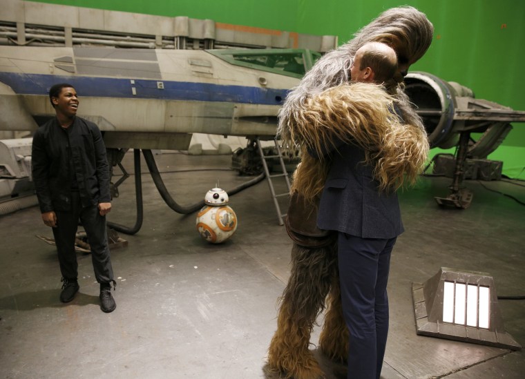 Image: Britain's Prince William is hugged by Chewbacca as British actor John Boyega smiles during a tour of the Star Wars sets at Pinewood studios in Iver Heath, west of London